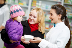 pharmacist handing a child a box of medicine