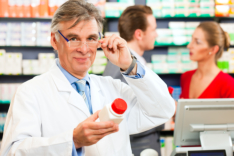 male pharmacist holding a bottle of medicine